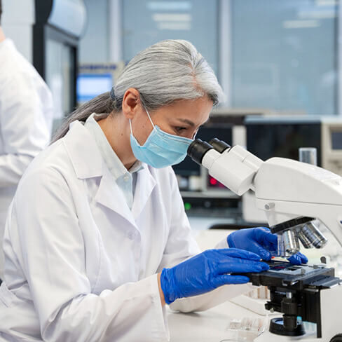 woman looking through microscope